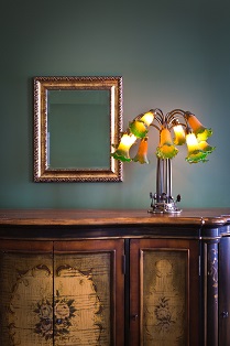 Close-up of interior design architecture with classical theme. A art Nouveau lighting fixture with mirror on a cabinet. Photographed in vertical format with copy space.
